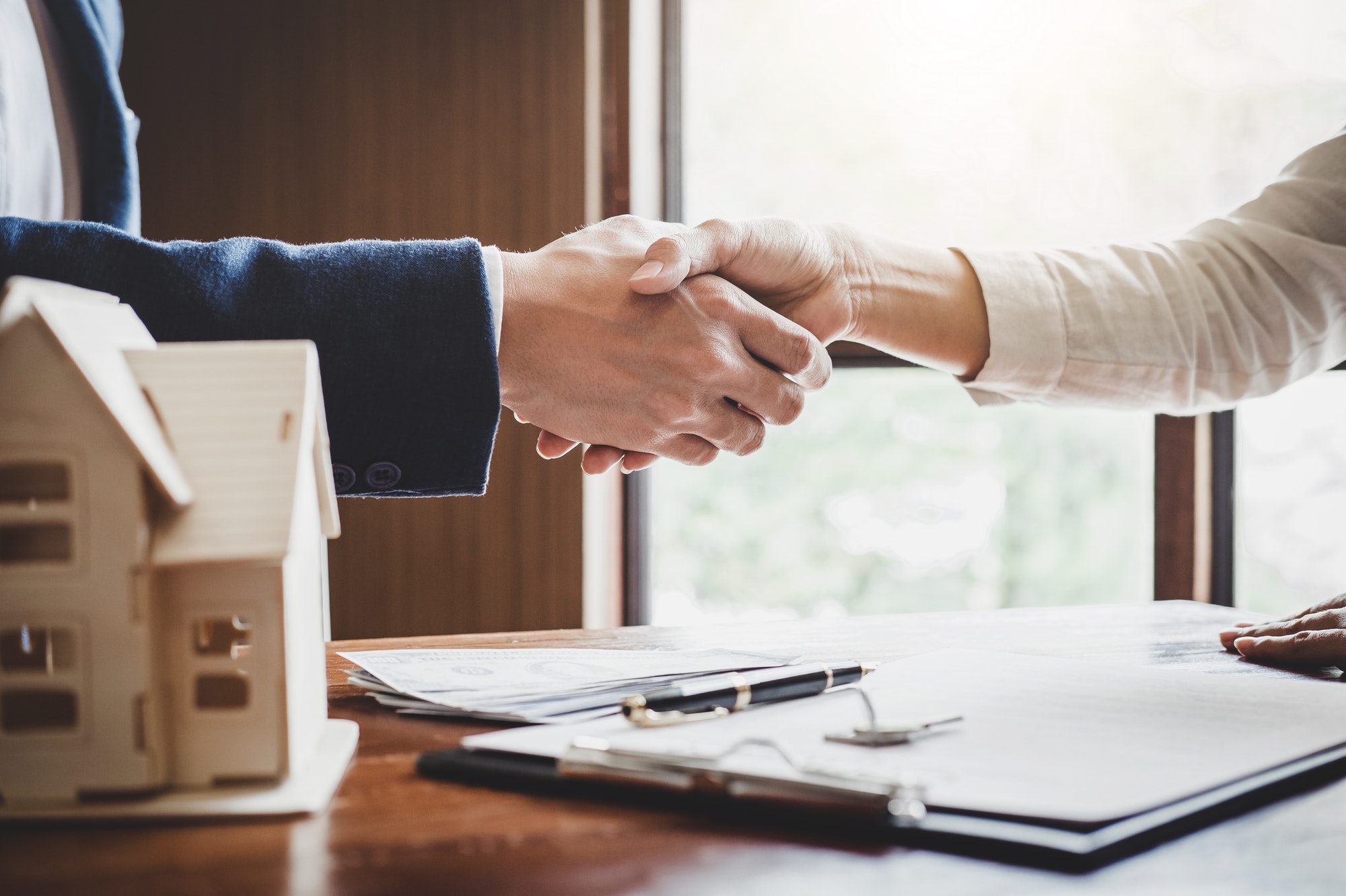 real-estate-agent-and-customers-shaking-hands-together-celebrating-finished-contract-after-about.jpg